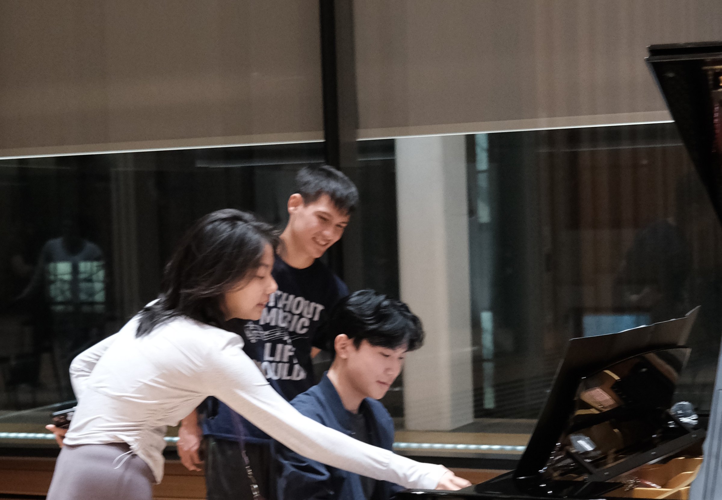 A member guiding another at the keyboard during a peer tutoring session